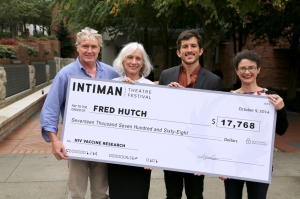 Big check passing from Fred Hutch to Intaman Theater on Oct. 9, 2015.